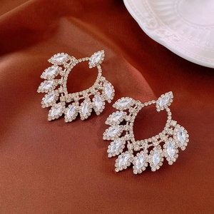 Macro detail of luxury silver earrings with marquise cut cubic zirconia on silk fabric