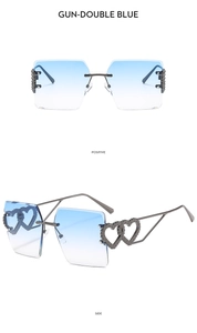 Detail view of rimless gunmetal sunglasses with double heart hollow hinges and blue lenses