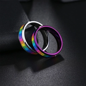 Macro detail of silver and purple titanium rainbow rings with LGBTQ pride flag inlay