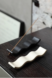 Détail de porte-encens minimalistes en céramique en forme de vague, noir et beige mat