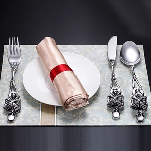 Detailed view of silver stainless steel flatware set with creative skull handle design