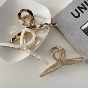 Detail view of large 13cm acetate hair claws in tortoise shell, pearl white and beige marble