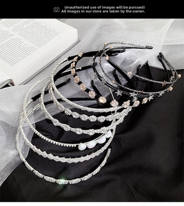 Detailed view of rhinestone and pearl metal headbands on elegant lace and satin background