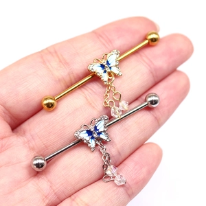 Detail of butterfly industrial barbell earrings with blue enamel and crystal charms