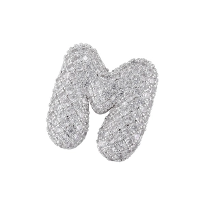 Macro shot of silver letter M pendant with paved cubic zirconia showing intricate metal setting