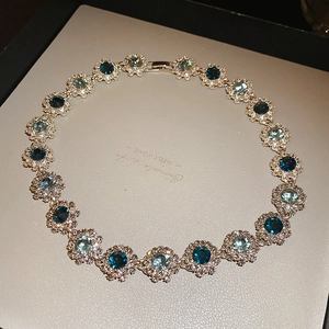 Detail of vintage flower necklace with blue crystal petals and micro-pave diamond accents