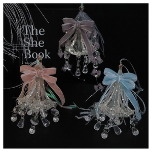 Detailed view of crystal glass ornaments with velvet bows and delicate feathers
