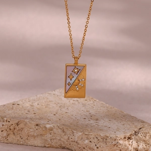 Macro detail of gold tarot necklace pendant with shell inlay, sun and star motifs
