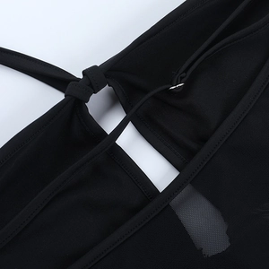 Detail of black mesh fabric stitching and shoulder strap knot on the sexy bodysuit