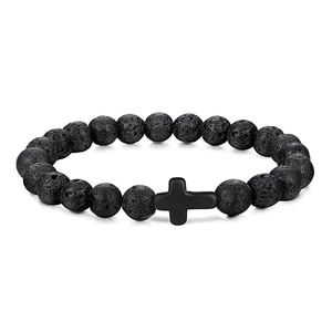 Macro detail of black volcanic stone beads and matte cross pendant on men's bracelet