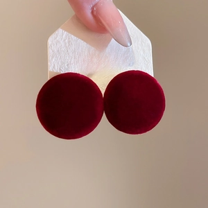 Macro detail of wine red velvet round stud earrings with S925 silver needles on card