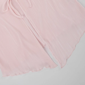 Close-up of light pink pleated fabric featuring lace-up drawstring and wavy hem details