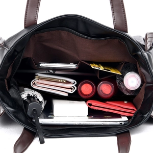 Spacious black leather handbag showing organized interior with laptop and essentials
