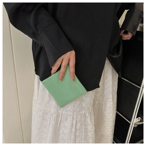 Slim mint green leather card holder being held to show thin profile and minimalist design