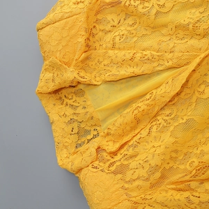 Dettaglio ravvicinato della trama in pizzo floreale giallo e fodera dell'abito da vacanza