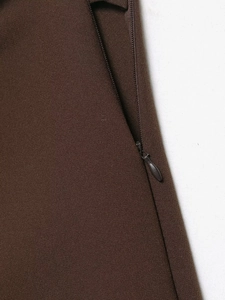 Detail view of the hidden side zipper and woven fabric texture on dark brown skort