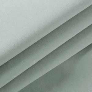 Gros plan détaillé sur la texture du tissu sergé vert gris et la densité des fibres