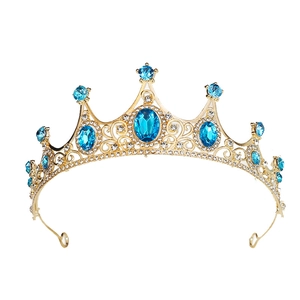 Macro shot of gold tiara featuring blue oval stones and sparkling white rhinestones