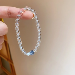 Détail du bracelet en perles de cristal blanc rond avec perles bleues sur la main