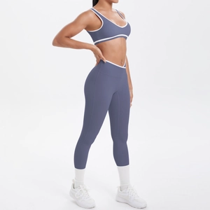 Detail der High-Waist-Yogahose und des Sport-BHs mit weißen Kontrastkanten in Graublau