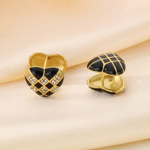 Macro detail of heart-shaped checkerboard earrings with enamel and crystal accents