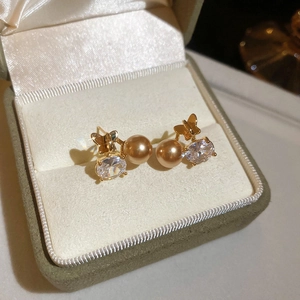 Macro di un orecchino a lobo a fiore placcato oro 18K con perla e zircone in scatola