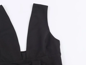 Détail de l'encolure en V profonde et texture du tissu tissé sur une robe noire élégante