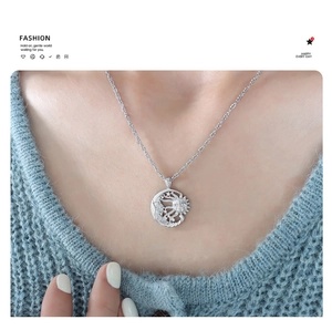 Macro detail of silver sun and moon pendant necklace worn on neck for a dreamy style