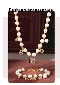 Detail of 18k gold plated pearl necklace and bracelet set with numeric pendants on vintage book