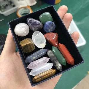 Coffret de cristaux naturels avec prismes hexagonaux et pierres polies tenus dans la main