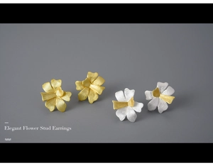 Macro detail of elegant petal-shaped stud earrings in brushed gold and silver finishes