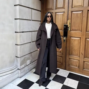 Deep brown long wool coat with wide lapels and double-breasted buttons in a street view