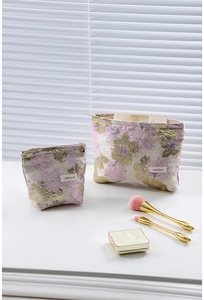 Détail de trousses à maquillage en jacquard rose et or en deux tailles avec fermeture éclair