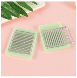 Miniature dollhouse BBQ grill set with light green trays and silver grids on pink background