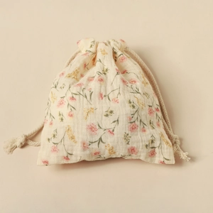 Macro view of floral muslin drawstring storage bag with premium cotton texture and rope