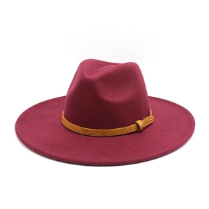 Close-up of wide brim burgundy fedora with textured brown band and buckle detail