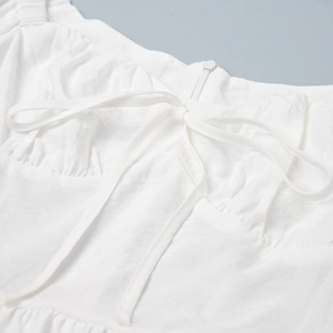 Nahaufnahme des Ausschnitts an weißem Kleid mit Schleife und verdecktem Reißverschluss