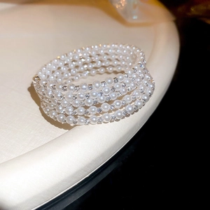 Vue macro d'un bracelet multi-rangs en perles blanches et strass étincelants