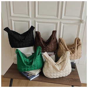 Detailed collection of quilted tote bags in five colors on a rustic wooden table setup