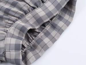 Vue détaillée du motif à carreaux gris et beige avec plis à la taille et couture de poche