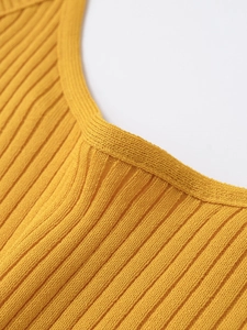 Close-up of vibrant yellow ribbed knit fabric texture and high-quality neckline stitching