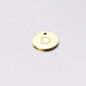 Macro detail of a 12mm golden stainless steel round pendant with an engraved letter D