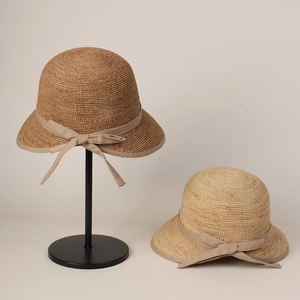 Detail of premium raffia sun hat with bow tie and elegant woven texture display