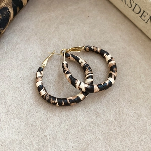 Close-up of leopard pattern wrapped hoop earrings with gold hardware and S925 silver needle