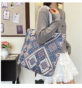 Detailed texture of blue and white ethnic geometric embroidery on canvas tote bag