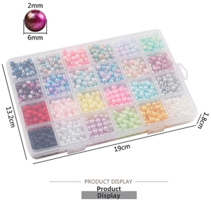 Macro detail of 6mm faux pearls with 2mm holes in a 24-grid organizer for DIY crafts