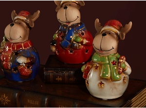 Detail of ceramic reindeer figurines with star cutouts on vintage books for Christmas decor