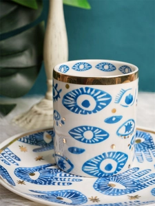 Macro shot of evil eye ceramic mug with gold rim and exotic palm pattern decoration