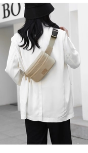 Detail view of khaki nylon waist bag with adjustable strap and SHENGAO leather patch logo