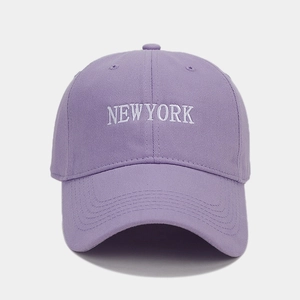Dettaglio del ricamo bianco NEW YORK su un cappellino da baseball color lavanda